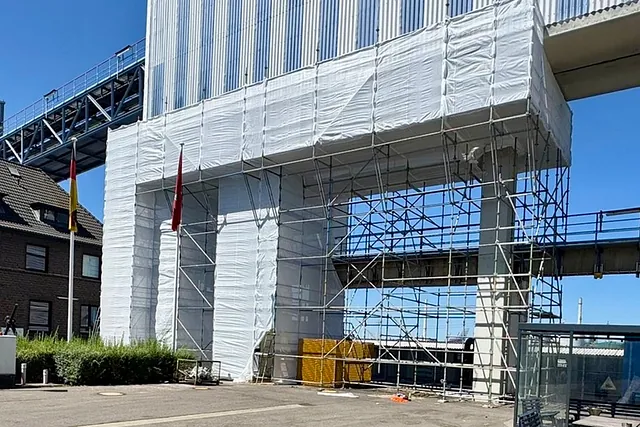 Große Industrieanlage mit mehrstöckigem Industriegerüst und weißer Schutzeinhausung für Wartungs- und Instandhaltungsarbeiten im Raum Hamburg.