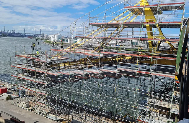 Gerüstbauer bei der Montage einer mehrgeschossigen Industriegerüstkonstruktion an einer Hafenanlage, Spezialgerüstbau von VVV Gerüstbau.